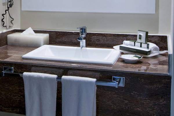 Badezimmer im Hotel Allegro Playacar mit Waschbecken, Handtüchern und Toilettenartikeln.