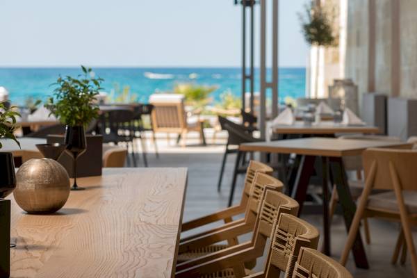 Innenansicht des Restaurants von Ikones Seafront Luxury Suites mit Blick auf das Meer.
