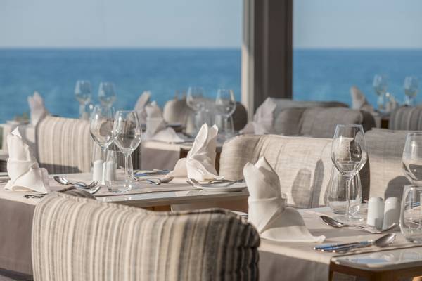 Meerblick Restaurant der Ikones Seafront Luxury Suites mit gedeckten Tischen und Blick auf das Meer
