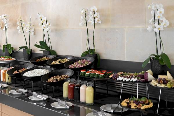 Frühstücksbuffet im Ikones Seafront Luxury Suites Hotel mit verschiedenen Gerichten und Getränken.