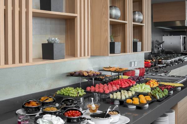 Frühstücksbuffet im Ikones Seafront Luxury Suites Hotel mit verschiedenen Früchten und Desserts.