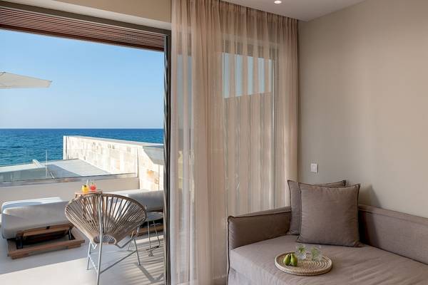 Aussicht von der Ikones Seafront Luxury Suite mit Meerblick, Terrasse und Möbeln.