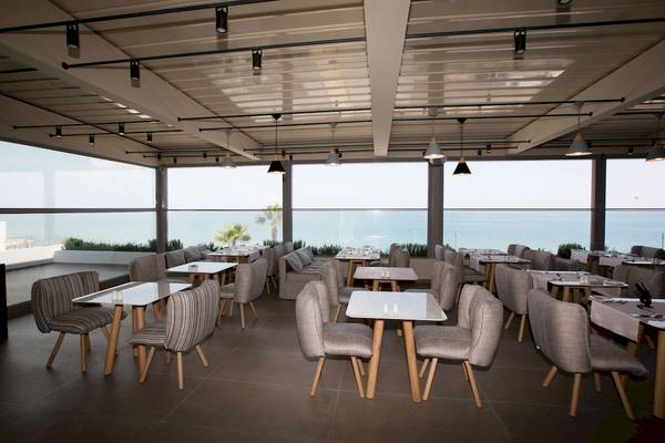 Innenansicht des Restaurants von Ikones Seafront Luxury Suites mit Meerblick.
