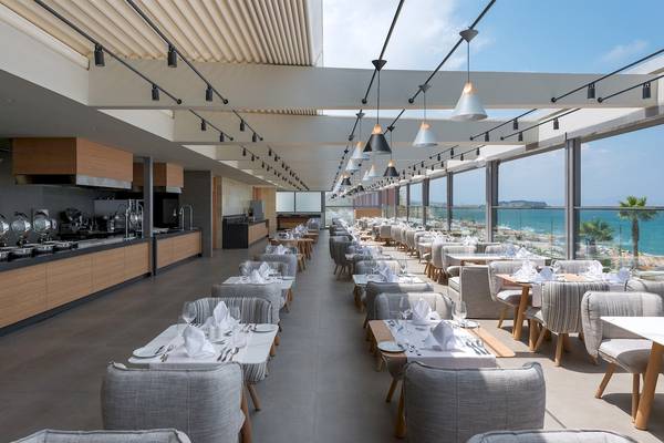 Innenansicht des Restaurants im Ikones Seafront Luxury Suites mit Blick auf das Meer.