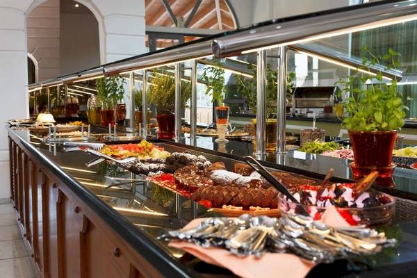 Buffet-Tisch im Arion Hotel Samos mit verschiedenen Speisen und Pflanzen in Töpfen.