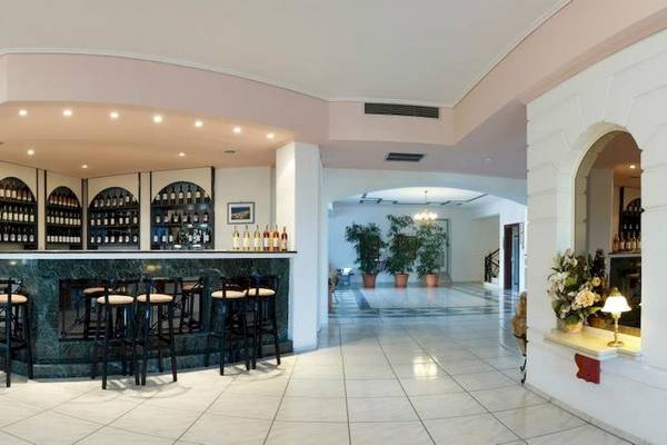 Innenansicht der Bar im Arion Hotel Samos mit grüner Theke und schwarzen Stühlen.