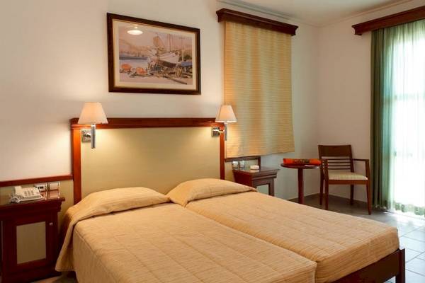 Doppelzimmer im Arion Hotel Samos mit zwei Betten, Nachttischen, Lampen und einem Gemälde an der Wand.