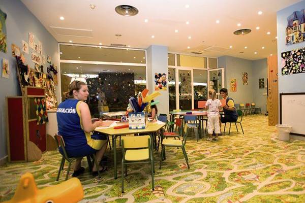 Kinderbetreuung im Hotel Maspalomas Princess mit einer Frau und Kindern an einem Tisch.
