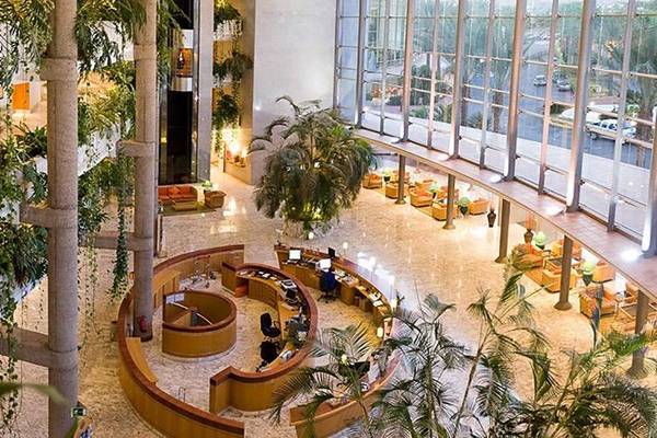 Empfangshalle des Maspalomas Princess Hotels mit Rezeption und grünen Pflanzen.