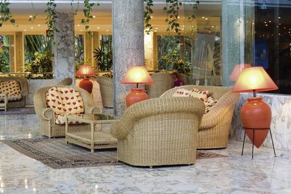 Lobby des Maspalomas Princess Hotels mit Korbsofas, Lampen und Marmorboden.