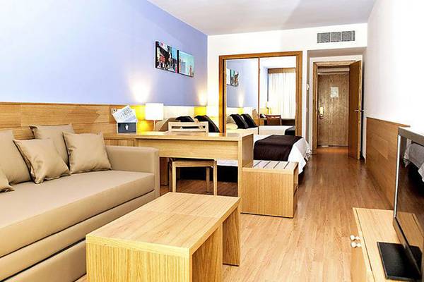 Hotelzimmer des Maspalomas Princess mit Sofa, Schreibtisch und Fernseher.