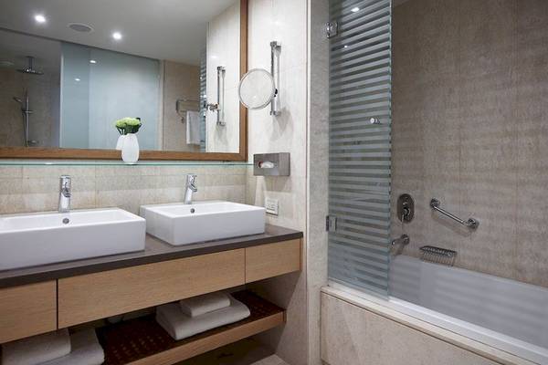 Badezimmer von Elite Suites by Rhodes Bay mit zwei Waschbecken, einem Spiegel und einer Badewanne.