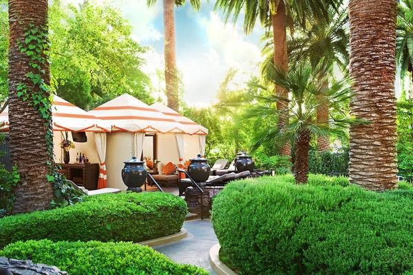 Außenbereich des Mirage Hotel & Casino mit zwei orange-weiß gestreiften Zelten und Palmen.