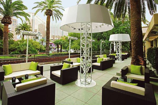 Terrasse im Mirage Hotel & Casino mit weißen Lampenschirmen und grünen Kissen.