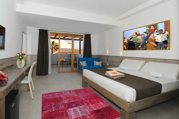 Innenansicht eines Zimmers im Sobrado Hotel mit Bett, Tisch, Fernseher und Gemälde.
