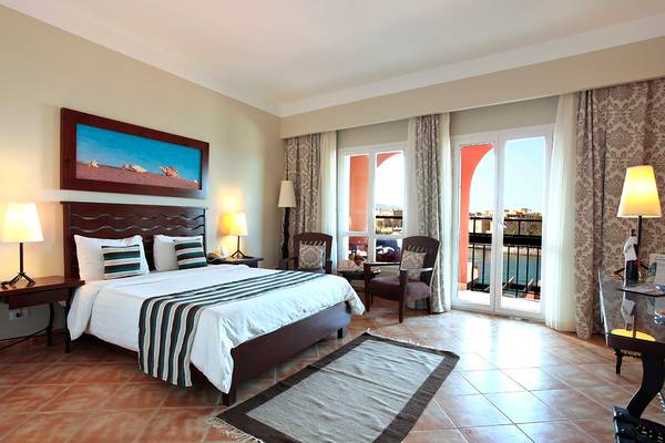 Ein geräumiges Schlafzimmer im Three Corners Ocean View Hotel mit Blick auf das Meer.