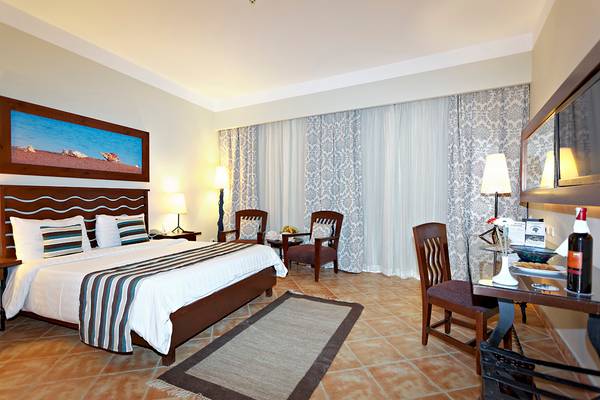 Schlafzimmer im Three Corners Ocean View Hotel mit Doppelbett, Sesseln und Schreibtisch