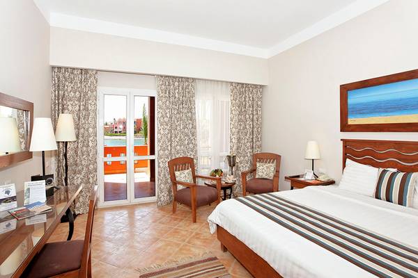 Zimmer im Three Corners Ocean View Hotel mit Blick auf die Terrasse und das Meer.