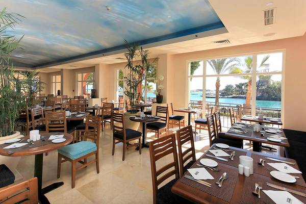 Innenansicht des Restaurants des Three Corners Ocean View Hotel mit Blick auf das Meer.