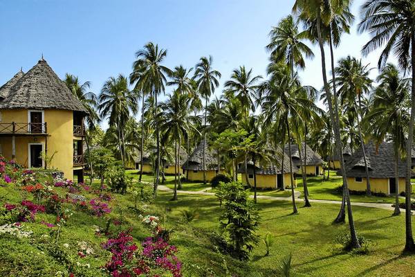 Das Ocean Paradise Resort & Spa mit gelben Hütten und Palmen im Hintergrund.