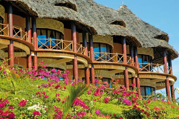 Außenansicht des Ocean Paradise Resort & Spa mit tropischen Blumen und Strohdächern