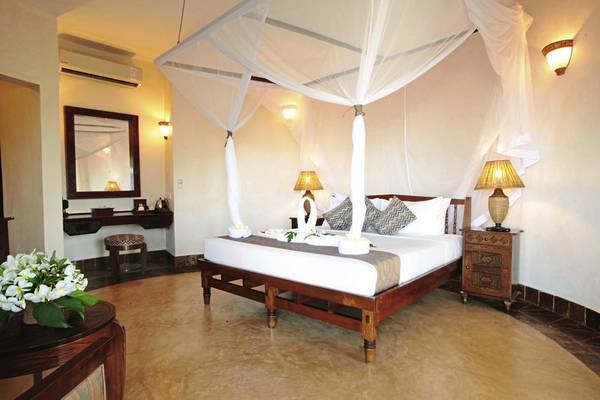 Schlafzimmer im Ocean Paradise Resort & Spa mit einem großen Bett, Vorhängen und Dekoration.