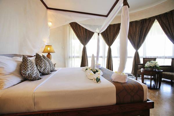 Schlafzimmer im Ocean Paradise Resort & Spa mit Bett, Lampen und Blumendekor