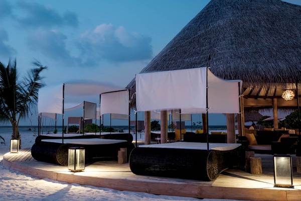 Außenbereich des Drift Thelu Veliga Retreat mit Strandbetten und Überdachungen