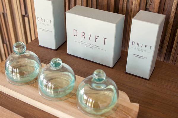Drei weiße Drift-Produkte mit Glasbehältern auf einem Tisch.