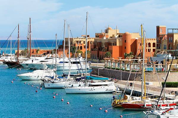 Ein Hafen mit vielen weißen und gelben Booten, die vor dem Dreieck Ocean View Hotel verankert sind.