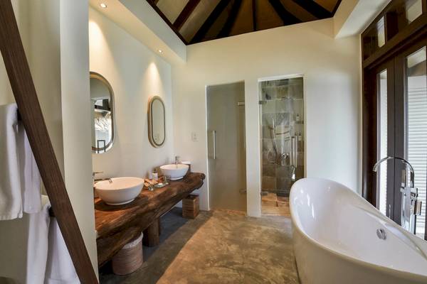 Badezimmer mit Doppelwaschbecken und Badewanne im Drift Thelu Veliga Retreat