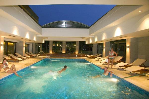 Einige Gäste entspannen und schwimmen im beheizten Innenpool des D'Andrea Mare Beach Hotels.