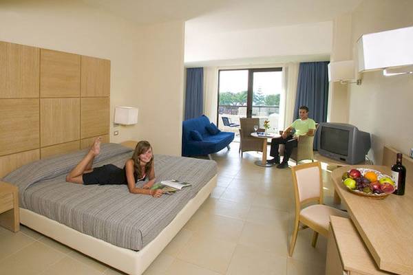 Junge Frau liegt auf einem Bett im D'Andrea Mare Beach Hotel Zimmer