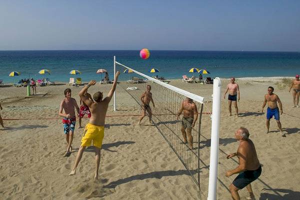 Gruppe von Männern spielt Volleyball auf dem Strand des D'Andrea Mare Beach Hotel.