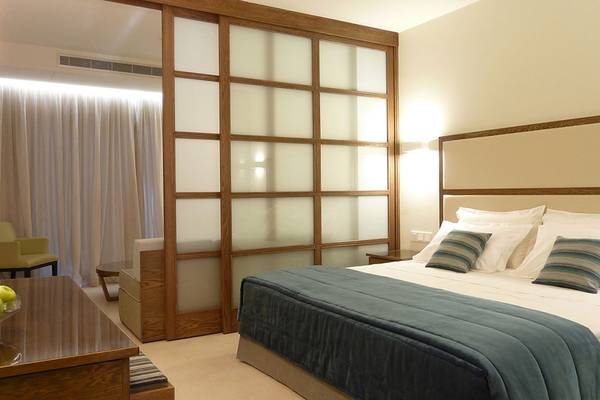 Suite-Zimmer im Sunrise Pearl Hotel & Spa mit Doppelbett und Frühstückstablett.