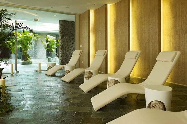 Spa-Bereich des Sunrise Pearl Hotel mit weißen Liegen und Holzwänden.