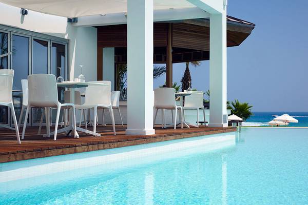Außenbereich des Sunrise Pearl Hotel & Spa mit Tischen und Stühlen am Pool
