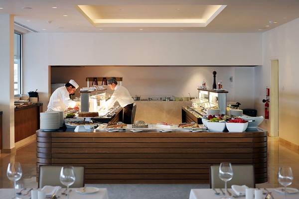 Buffettisch im Sunrise Pearl Hotel & Spa mit zwei Köchen, die Speisen zubereiten.