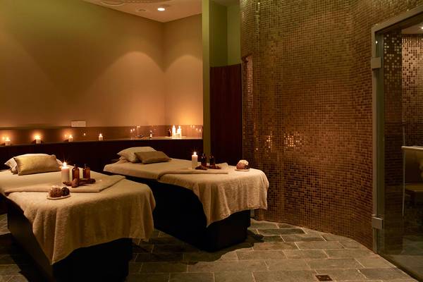 Spa-Behandlungsraum im Sunrise Pearl Hotel & Spa mit zwei Betten, Kerzen und Mosaikwänden.