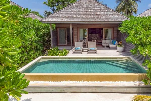 Villa des Hurawalhi Island Resorts mit privatem Pool, umgeben von Pflanzen und Möbeln auf der Terrasse