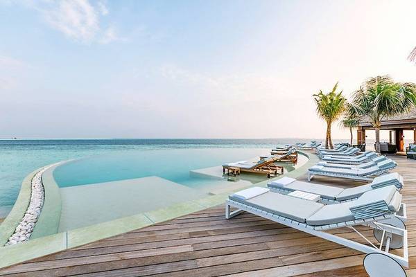 Unendlicher Pool mit Loungeliegen am Hurawalhi Island Resort