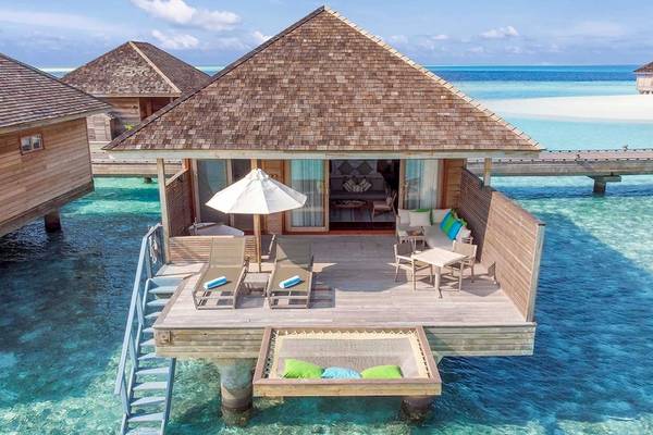 Luftaufnahme einer Wasservilla im Hurawalhi Island Resort mit Strand und Meer im Hintergrund.