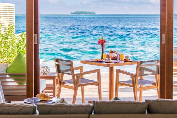 Aussicht auf das Meer vom Hurawalhi Island Resort aus, mit einem Tisch und Stühlen auf der Terrasse.