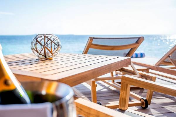 Terrasse mit Flasche Champagner am Hurawalhi Island Resort mit Blick auf das Meer