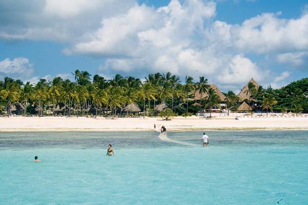 Einige Leute sind im Meer und auf dem Strand am Karafuu Beach Resort & Spa.