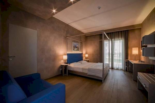Schlafzimmer im Cala Ponte Hotel mit einem Bett, einer Couch und Schreibtisch