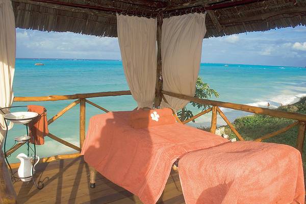 Massageliege auf der Terrasse des Karafuu Beach Resort & Spa mit Blick auf das Meer.