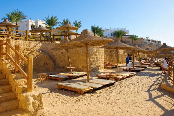 Strandbereich des Sharm Plaza Hotels mit Liegen und Strohhut-Sonnenschirmen