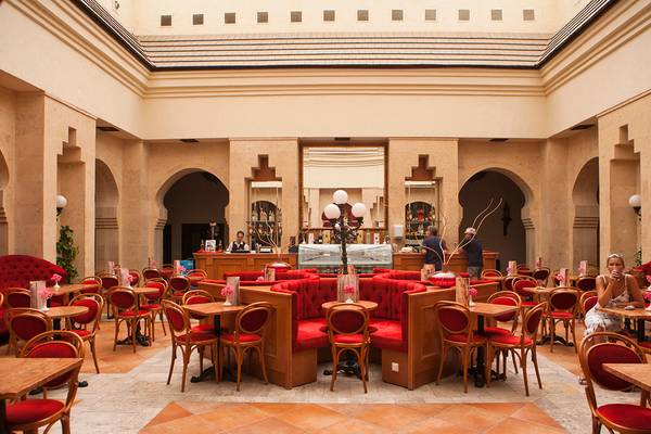 Innenansicht des Restaurants im Sharm Plaza Hotel mit roten Sesseln und Tischen.