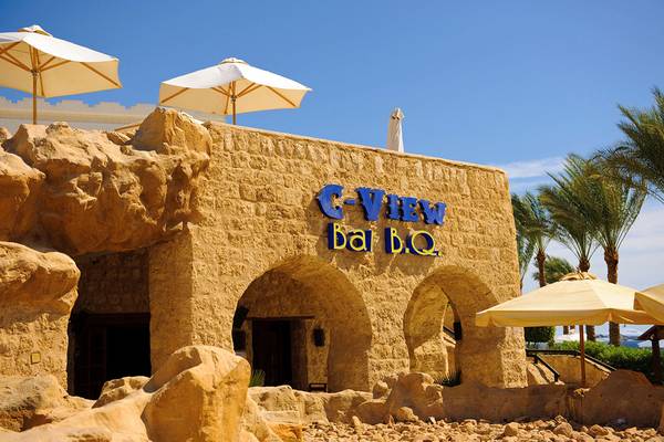 Außenansicht des C-View Bar BBQ im Sharm Plaza Hotel mit Steinmauer und blauem Schriftzug